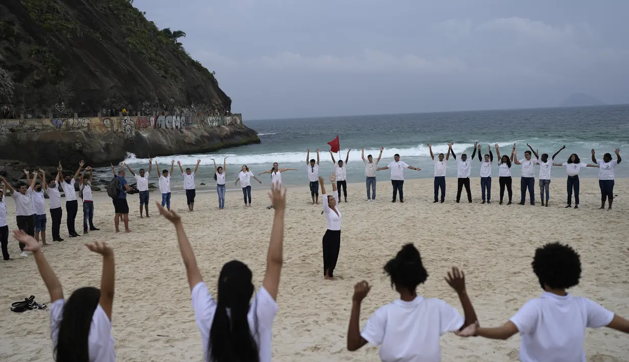 Orang-orang berkumpul di sepanjang pantai Copacabana pada Hari Laut Sedunia di Rio de Janeiro, Brasil, Rabu (8/9/2022). Organisasi Route Brasil menyerukan agar orang-orang berkumpul untuk acara yang diberi nama "Pelukan Itu," dan untuk memungut sampah di pantai, untuk menarik perhatian pada pencemaran laut. (AP Photo/Silvia Izquierdo)