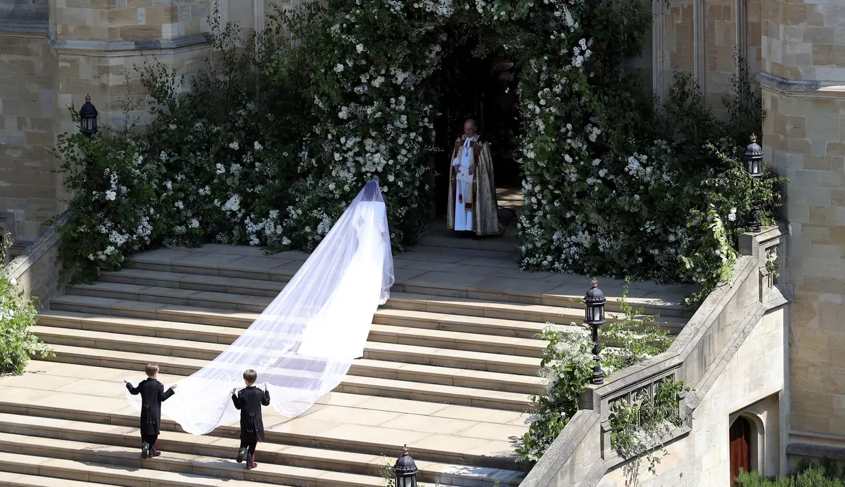Meghan Markle tiba untuk melangsungkan pernikahannya dengan Pangeran Harry di St George's Chapel, Kastil Windsor, Windsor, Inggris, Sabtu (19/5). Meghan mengenakan gaun putih panjang di hari pernikahannya. (Andrew Matthews/POOL/AFP)