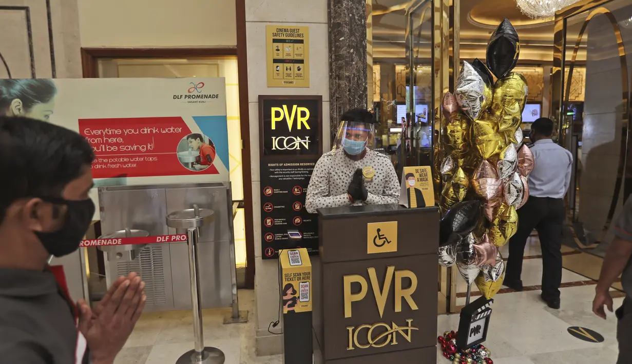 Seorang karyawan menyambut para pejuang COVID-19 dan keluarganya saat bioskop dibuka kembali di bioskop PVR di New Delhi, India (15/101/2020). Salah satu jaringan bioskop terbesar di India, PVR Cinemas, menyatakan telah mulai beroperasi mulai hari ini, Kamis (15/10). (AP Photo/Manish Swarup)