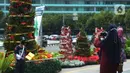 Warga berfoto dengan latar hiasan pohon Natal 2021 di Bundaran HI, Jakarta, Sabtu (25/12/2021). Libur Natal 2021 dimanfaatkan sebagian warga berfoto berlatar pohon Natal yang telah dihias atau berjalan-jalan ke mal untuk mengisi waktu berlibur bersama. (merdeka.com/Imam Buhori)