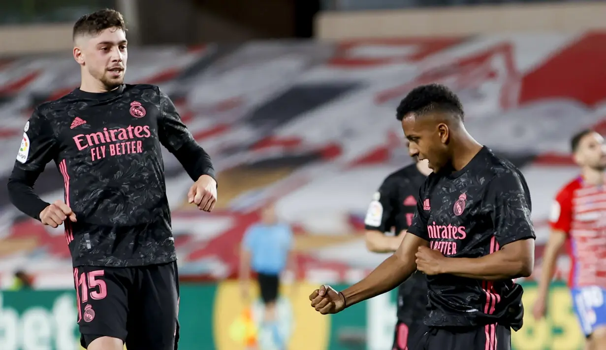 Striker Real Madrid, Rodrygo (kanan) melakukan selebrasi usai mencetak gol kedua timnya ke gawang Granada dalam laga lanjutan Liga Spanyol 2020/2021 pekan ke-36 di Los Carmenes Stadium, Granada, Kamis (13/5/2021). Real Madrid menang 4-1 atas Granada. (AP/Fermin Rodriguez)