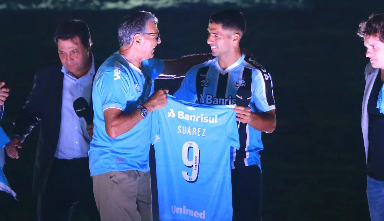 Striker Uruguay Luis Suarez menerima jersey saat sesi perkenalannya sebagai pemain baru Gremio di stadion Gremio Arena, di Porto Alegre, Brasil, Rabu (4/1/2023). Mantan pemain Barcelona dan Atletico Madrid itu memakai jersey nomor 9 di Gremio. (Silvio AVILA / AFP)