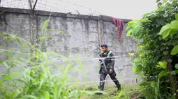 Polisi bersenjata lengkap berpatroli di sekitar pagar parimeter penjara menyusul serangan sekelompok pria bersenjata di kota Kidapawan, selatan Filipina, Rabu (4/1). Disinyalir pelaku penyerangan adalah pemberontak Muslim. (Ferdinandh CABRERA/AFP)