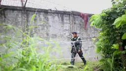 Polisi bersenjata lengkap berpatroli di sekitar pagar parimeter penjara menyusul serangan sekelompok pria bersenjata di kota Kidapawan, selatan Filipina, Rabu (4/1). Disinyalir pelaku penyerangan adalah pemberontak Muslim. (Ferdinandh CABRERA/AFP)