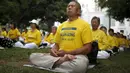 Salah satu aktivis melakukan meditasi Falun Gong sebelum demonstrasi menentang pemerintah China, di luar Balaikota Los Angeles, California, Kamis (15/10). Presiden China Xi Jinping akan melakukan kunjungan kenegaraan di Washington.(REUTERS/Lucy Nicholson)