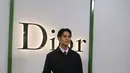 Ia memadukan kemeja putih dengan dasi panjang merah yang dibalut dengan workwear empat kantung