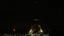 Lampu Menara Eiffel di Paris dipadamkan sebagai penghormatan kepada korban serangan teroris di Masjid Bir el-Abd, Semenanjung Sinai, Mesir (24/11). Saat ini belum ada kelompok yang secara resmi mengaku sebagai pelaku serangan. (AFP Photo/Thomas Samson)