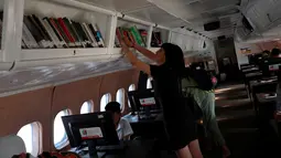 Seorang wanita memilih buku saat berada dalam pesawat McDonnell Douglas DC 9-14 yang diubah menjadi perpustakaan virtual di Mexico City, Meksiko  (14/3). (Reuters/Henry Romero)