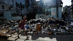 Penyebabnya karena kekurangan bahan bakar dan suku cadang kendaraan yang berdampak pada pengumpulan sampah di pulau yang lumpuh akibat sanksi dan kesengsaraan ekonomi. (YAMIL LAGE / AFP)