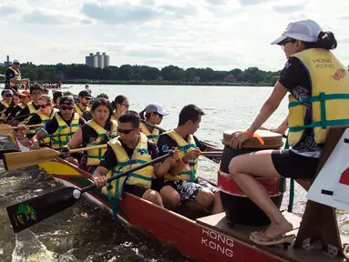 Rombongan peserta mendayung perahu menuju garis start balapan Festival Perahu Naga Hong Kong di Queens, New York, Minggu (13/8). Festival ini merupakan acara olahraga dan multikultural tahunan terbesar di Amerika Serikat. (AP/Andres Kudacki)