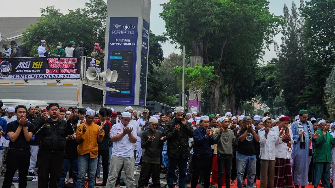Massa demonstran juga melakukan aksi salat berjemaah di tengah Jalan Asia-Afrika selama menggelar aksi demo menolak konser Coldplay.