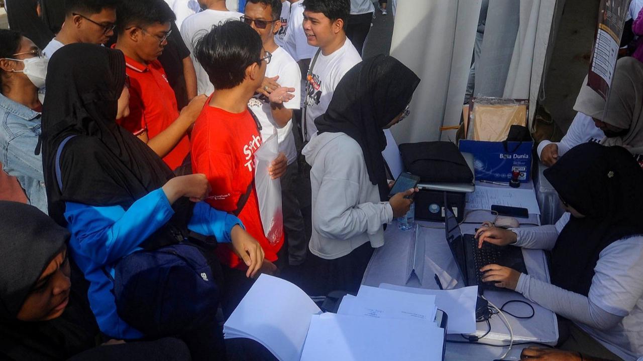 Warga mengantre melakukan pengurusan surat pindah TPS (Tempat Pemungutan Suara) Pemilu pada stand yang digelar KPU di kawasan Bundaran HI, Jakarta, Minggu (14/01/2023).