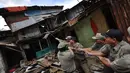 Sejumlah petugas satpol PP saat menarik bangunan liar di kawasan rusun tanah tinggi, Jakarta, Rabu (4/3/2015).  Sebanyak 10 bangunan liar di Rumah Susun (Rusun) Tanah Tinggi ditertibkan aparat satpol PP. (Liputan6.com/Faizal Fanani)