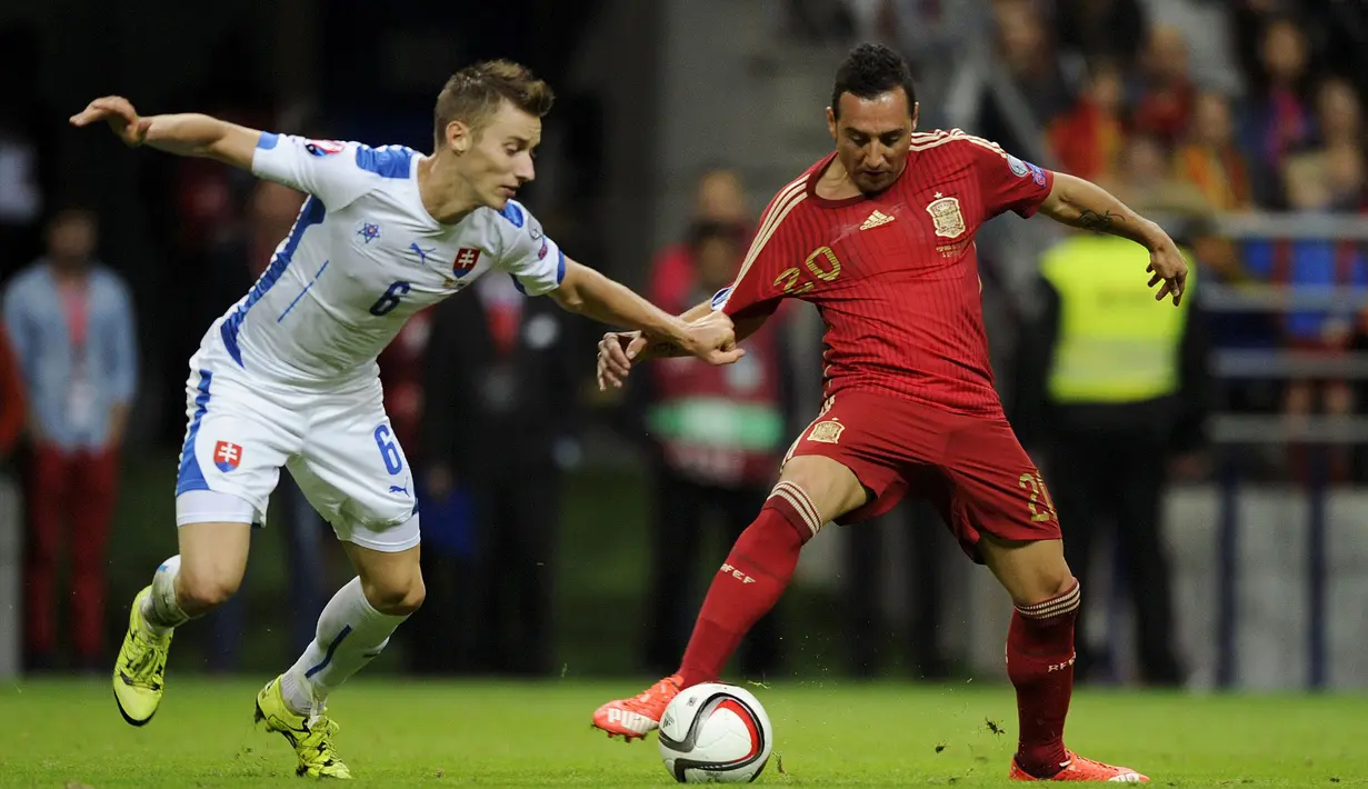 Gelandang Spanyol, Santi Cazorla berusaha melewati hadangan pemain Slovakia, Jan Gregus pada laga kualifikasi Piala Eropa 2016 di Stadion Carlos Tartiere, Spanyol, Sabtu (5/9/2015). (Reuters/Eloy Alonso)