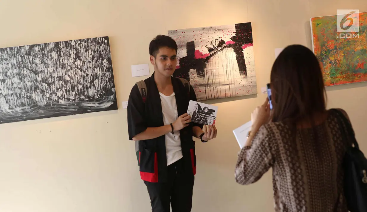 Pengunjung berpose di depan karya di pameran seni rupa bertajuk ‘Ekspresi Ragam Jiwa’ di Galeri Cipta III TIM, Jakarta, Rabu (4/4). Pameran menampilkan karya 24 seniman untuk memeringati Hari Bipolar Sedunia. (Liputan6.com/Immanuel Antonius)
