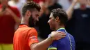 Petenis Spanyol, Rafael Nadal dan petenis Prancis, Benoit Paire usai babak pertama Prancis Terbuka 2017 di Stade Roland Garros, Senin (29/5). Nadal mengalahkan tuan rumah dengan skor 6-1, 6-4, 6-1. (AP Photo/Petr David Josek)