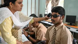 Sebuah sekolah tunanetra di Hyderabad, India menggelar program pelatihan pengenalan sekaligus penggunaan kacamata pintar berteknologi Artificial intelligence (AI) untuk para siswa disabilitas netra. (NOAH SEELAM/AFP)