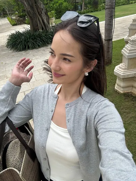 Salah satu look simpel tapi chic yang ditampilkan Enzy adalah perpaduan tank top putih polos dengan cardigan panjang abu-abu.   [@enzystoria].