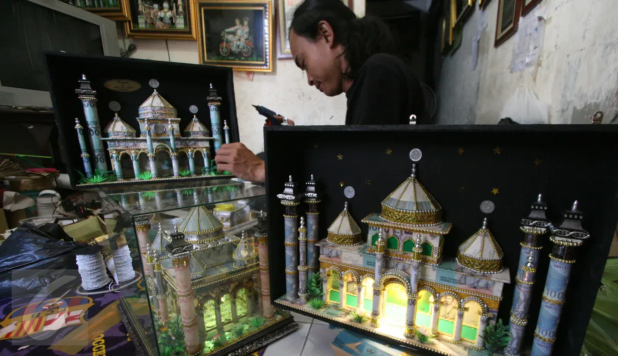 Seorang perajin, Albani, menyelesaikan mahar pernikahan berbentuk miniatur masjid, di dusun Jotowang, Yogyakarta, Rabu (15/6). Pada Ramadan, pemesanan miniatur masjid berbahan dasar uang pecahan rupiah itu mengalami peningkatan (Liputan6.com/Boy Harjanto)