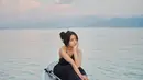 Menikmati waktunya bermain di pantai, Fuji tampil cantik dengan atasan cropped top bertali halter-neck dan celana panjang hitamnya yang serasi. [Foto: Instagram/fuji_an]