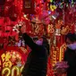 Seorang wanita memilih dekorasi Tahun Baru Imlek di sebuah mal di Beijing (16/1/2022). Beijing telah melaporkan infeksi omicron lokal pertamanya, beberapa minggu sebelum Olimpiade Musim Dingin akan dimulai. (AP Photo/Andy Wong)