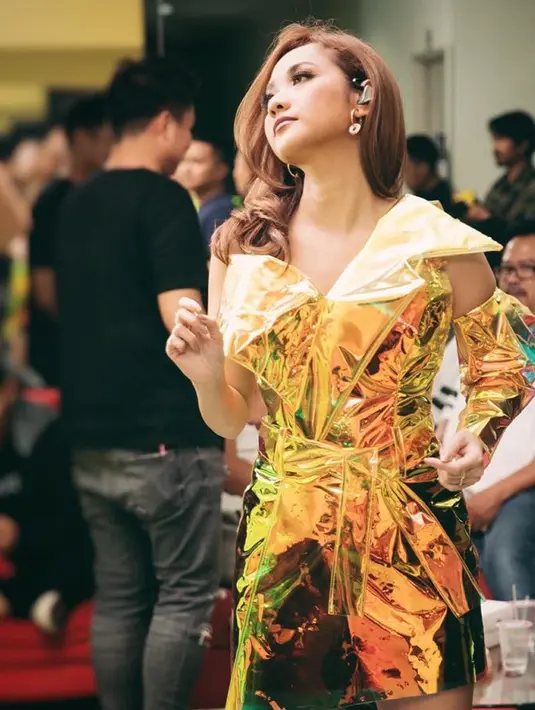 Wanita 39 tahun itu juga percaya diri dengan baju warna terang. Kali ini, ia tampil dengan dress berbahan mengkilat yang memiliki desain bagian lengan terbuka. Bunga Citra Lestari tampak makin menawan. (Liputan6.com/IG/@bclsinclair)