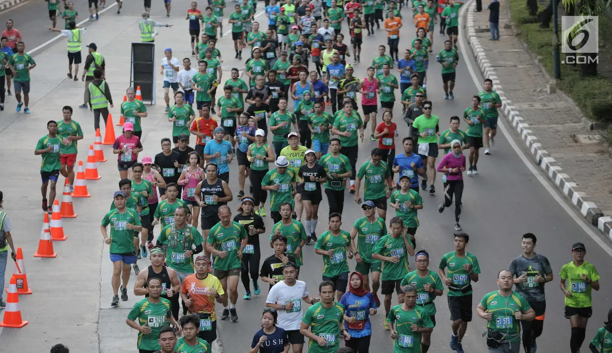 Peserta mengikuti lomba lari Milo Jakarta International 10K di kawasan Epicentrum, Jakarta, Minggu (15/7). Ajang lomba lari 10 Kilometer ini diikuti 16.000 peserta yang terbagi menjadi tiga kategori Open, Closed, dan Pelajar. (Liputan6.com/Faizal Fanani)