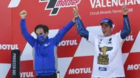 Pemabalap Suzuki Esctar, Joan Mir, melakukan selebrasi bersama manajer Davide Brivio usai balapan MotoGP Valencia di Sirkuit Ricardo Tormo, Minggu (15/11/2020). Meski finis ketujuh, Joan Mir berhasil mengunci gelar juara dunia MotoGP 2020. (AP/Alberto Saiz)