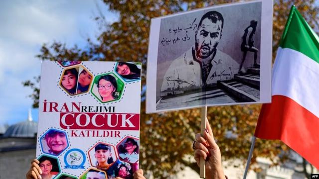 Aksi protes warga di Istanbul, dengan memegang potret rapper Iran Toomaj Salehi (kanan), dan anak-anak (kiri) yang terbunuh selama protes di Iran, 26 November 2022. (File AFP)