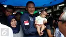 Calon Gubernur DKI Jakarta Agus Harimurti Yudhoyono menggendong seorang balita saat mengunjungi Pasar Paseban Jakarta Pusat, Jumat (11/11). Agus disambut hangat pedagang maupun pengunjung pasar tersebut. (Liputan6.com/Gempur M Surya)
