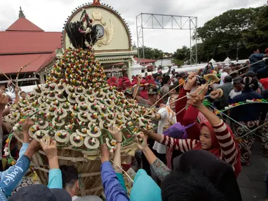 Warga berebut mengambil sesuatu di gunungan saat Grebeg Idul Adha, Yogyakarta, Selasa (13/9). Acara tahunan ini menjadi salah satu daya tarik kota Yogyakarta. (Liputan6.com/Boy Harjanto)