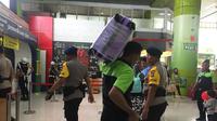 Seorang porter bernama Sarimani (47) mengangkat barang pemudik. (Liputan6.com/Lizsa Egeham)