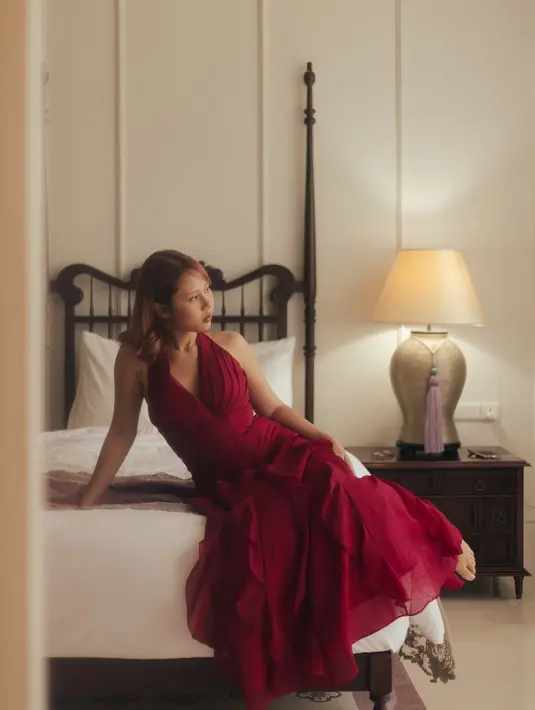 Bernuansa vintage, Nadin Amizah kenakan halterneck dress merah dengan aksen ruffle di beberapa sisi [@cakecaine]