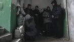 Orang-orang berlindung dari penembakan di dalam pintu masuk gedung apartemen di Mariupol, Ukraina, Minggu, 13 Maret 2022. Pada 24 Februari 2022, Rusia melancarkan invasi berskala besar ke Ukraina, salah satu negara tetangganya di sebelah barat daya. (AP Photo/Evgeniy Maloletka)