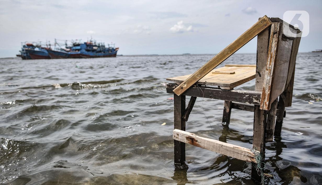 Sebuah bangku saat terendam banjir rob di Pelabuhan Kali Adem, Muara Angke, Jakarta, Kamis (22/10/2020). Banjir akibat air pasang dengan ketinggian mencapai 30 cm tersebut telah merendam kawasan Pelabuhan Kali Adem dan sudah berlangsung selama lima hari. (merdeka.com/Iqbal S. Nugroho)