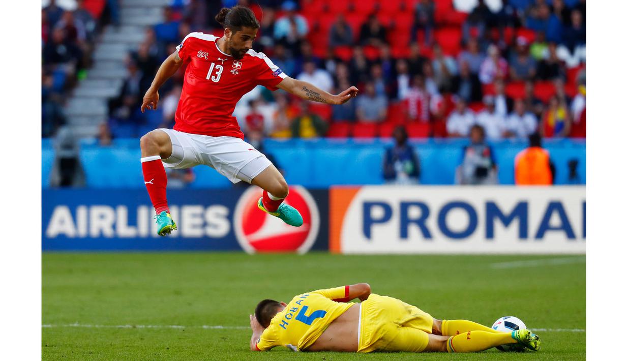 Pemain Swiss, Ricardo Rodriguez (kiri) menghindar dari terjangan pemain Rumania pada laga Grup A Piala Eropa 2016 di Parc des Princes, Paris, Rabu (15/6/2016) WIB. (REUTERS/Kai Pfaffenbach)
