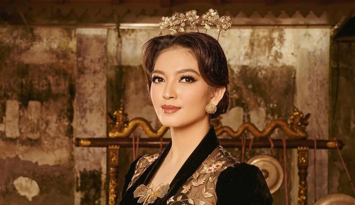 Aura putri Jawa memancar sempurna dari penampilan Selvi Ananda kali ini. Dengan kebaya modern berwarna hitam dengan bordir flora keemasan, makeup Selvi dihadirkan dalam nuansa cokelat yang hangat dan pas. Rambutnya digulung rendah ke belakang, poninya dibelah tengah, lalu diberi aksesori cunduk mentul dan bros emas yang memperindah keseluruhan penampilannya. [Foto: Instagram/doleytobing]