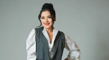 Tampil dengan kemeja putih dipadukan dengan blazer abu-abu dan kain lilit sebagai bawahannya, Fera Feriska bikin pangling. Rambut pemeran Dinda Lestari di sinetron Love Story The Series ini dicepol dengan juntaian di kiri dan kanannya. Makeup-nya flawless, namun Fera memoles bibirnya dengan lipstik warna merah yang membuat pesonanya semakin terpancar. (Liputan6.com/IG/@_feraferiska_)