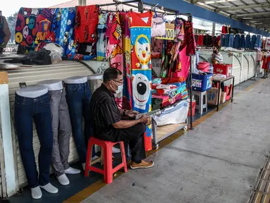 Pedagang menunggu pembeli di Jembatan Penyeberangan Multiguna atau Skybridge Tanah Abang, Jakarta, Jumat (19/6/2020). Kendati pusat perbelanjaan telah dibuka sejak 15 Juli 2020, aktivitas jual beli di Skybridge Tanah Abang terpantau sepi. (Liputan6.com/Faizal Fanani)
