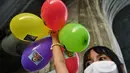 Seorang pelajar memegang balon saat melakukan demonstrasi menentang pembelian kapal selam oleh pemerintah yang berpihak pada militer di Bangkok (31/8/2020). (AFP/Lillian Suwanrumpha)
