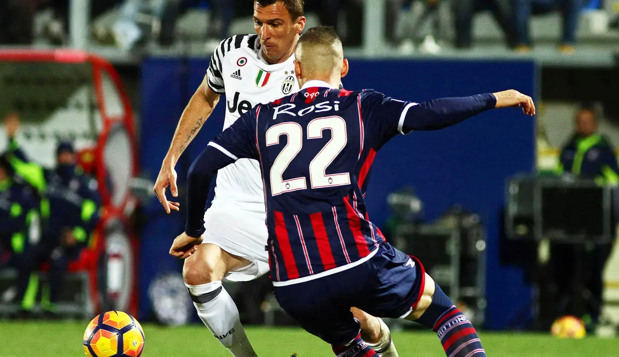 Striker Juventus, Mario Mandzukic, berusaha melewati pemain Crotone, Aleandro Rosi. Meski berstatus tamu, Juve lebih menguasai jalannya laga dengan penguasaan bola mencapai 76 persen. (EPA/Albano Angilletta)