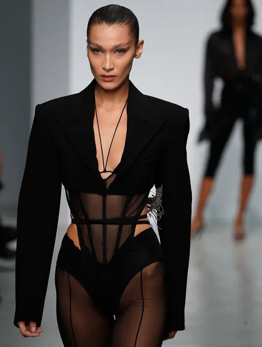 Model Bella Hadid mengenakan membawakan koleksi Spring 2020 dari Mugler dalam gelaran Paris Fashion Week, Rabu (25/9/2019). Bella Hadid tampil dalam balutan lingerie hitam transparan yang dipadukan dengan celana thong. (AP Photo/Francois Mori)