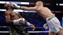 Conor McGregor melakukan pukulan tepat diwajah Floyd Mayweather dalam pertandingan tinju super kelas welter di Las Vegas (26/8). (AP Photo/Isaac Brekken)