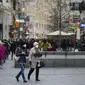 Orang-orang memakai masker saat mereka berjalan di jalan perbelanjaan di Wina, Austria, Rabu (17/11/2021).  Pemerintah Austria menetapkan penguncian nasional atau lockdown bagi warga yang tidak atau belum divaksinasi Covid-19. (AP Photo/Michael Gruber)