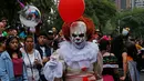Seorang pria mengenakan kostum tokoh film 'It' saat mengikuti parade Hari Orang Mati di Mexico City, Meksiko, Sabtu (26/10/2019. Para peserta dalam parade ini mengenakan kostum dan melukis wajah mirip dengan tokoh tengkorak Meksiko yang ikonik, Catrina. (AP Photo/Ginnette Riquelme)