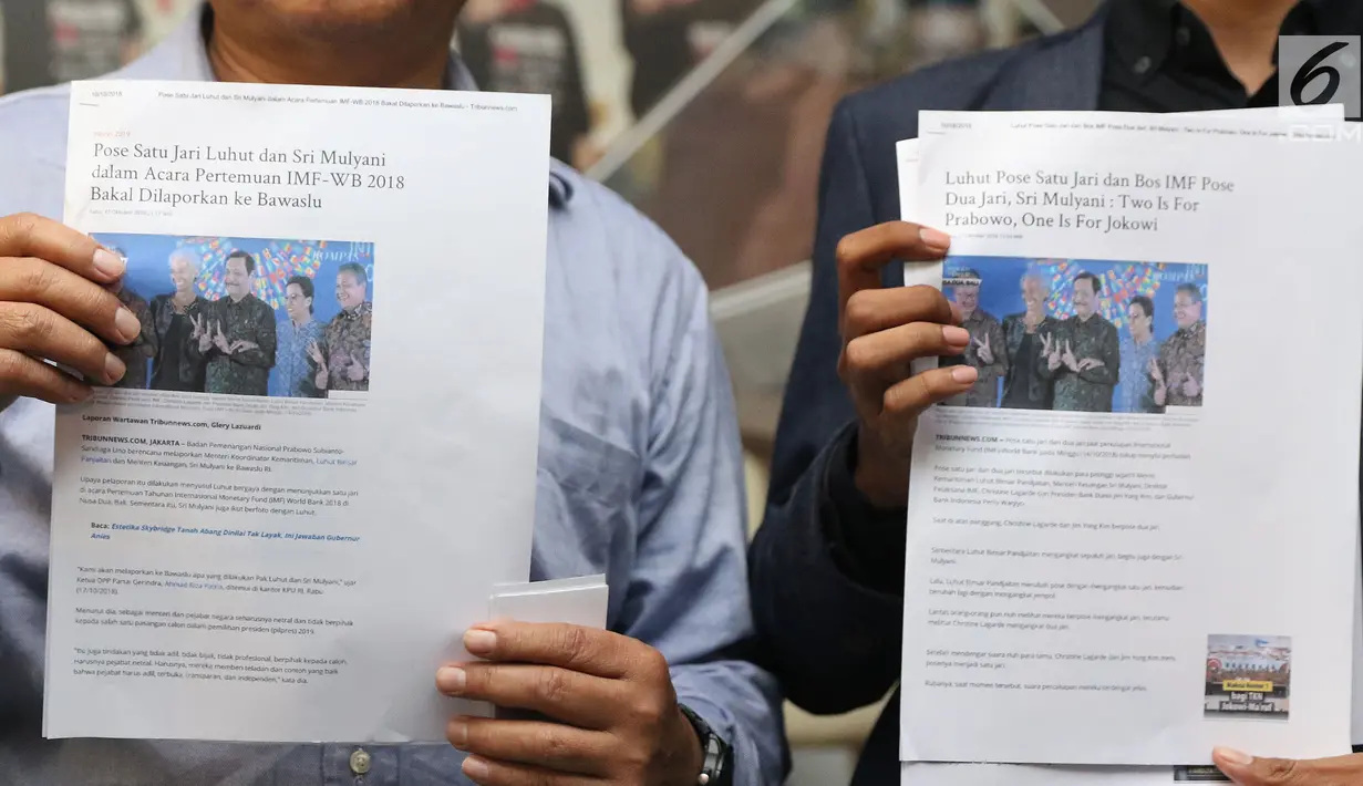 Bukti dugaan pelanggaran pemilu diperlihatkan jelang pembuatan pengaduan di Gedung Bawaslu, Jakarta, Kamis (18/10). Mereka melaporkan dugaan pelanggaran pemilu oleh menteri Luhut Binsar Pandjaitan dan Sri Mulyani. (Liputan6.com/Helmi Fithriansyah)