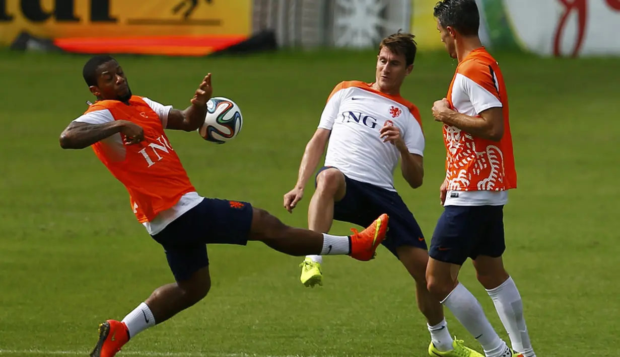 Pemain depan Timnas Belanda, Jeremain Lens (kiri), berebut bola dengan Paul Verhaegh (tengah) saat berlatih di Rio de Janeiro, (2/7/2014). (REUTERS/Pilar Olivares)