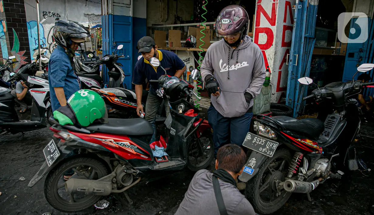 Sejumlah konsumen menunggu sepeda motornya diperbaiki usai terendam banjir di kawasan Mampang, Jakarta, Minggu (21/2/2021). Banjir yang melanda Ibu Kota Jakarta pada Sabtu (20/2) menyebabkan banyak kendaraan warga mengalami kerusakan akibat terendam air. (Liputan6.com/Faizal Fanani)