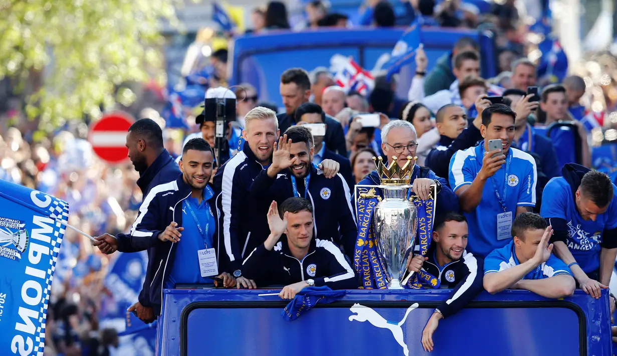 Sejumlah pemain dan staf dari Leicester City menaiki bus terbuka untuk mengarak piala liga Inggris yang di Inggris, (17/5). Sekitar 240.000 orang diperkirakan turun ke jalan merayakan juara bersama punggawa Leicester City. (Reuters / Darren Staples)