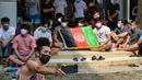 Pengungsi Afghanistan mengibarkan bendera negaranya untuk menunjukkan identitasnya di sebuah kamp pengungsi di Bekasi, Jawa Barat (20/8/2021). Mereka tidak bersedia kembali ke negaranya, terutama setelah Taliban mengambil alih kekuasaan dari pemerintahan Presiden Ashraf Ghani. (AFP/Bay Ismoyo)